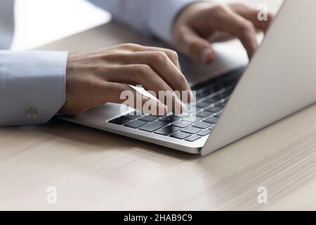 Businessman texting on laptop sit at workplace desk, close up Stock Photo