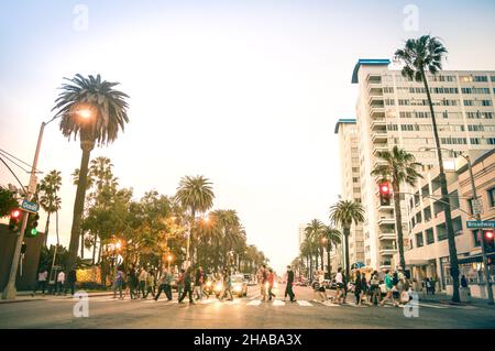 Locals and tourists walking on zebra crossing and on Ocean Ave in Santa Monica after sunset - Crowded streets of Los Angeles and California state Stock Photo