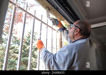 Senior constructor worker plaster around the window. Stock Photo