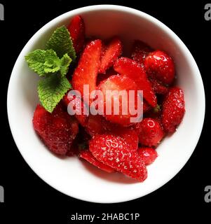 Photography of cut strawberries in ceramic bowl with fresh mint on ...