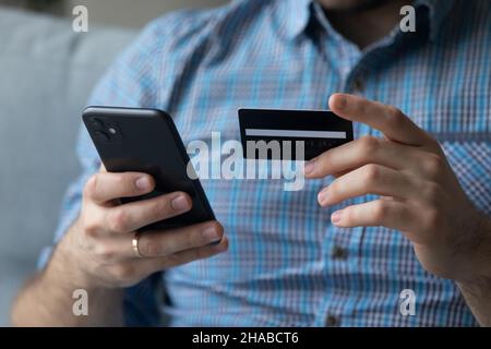 Man online using cellphone and debit card Stock Photo