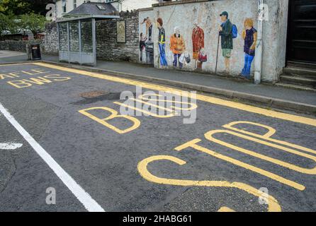 A bus stop with a mural depicting local people waiting for a bus, Builth Wells, Powys, Wales Stock Photo