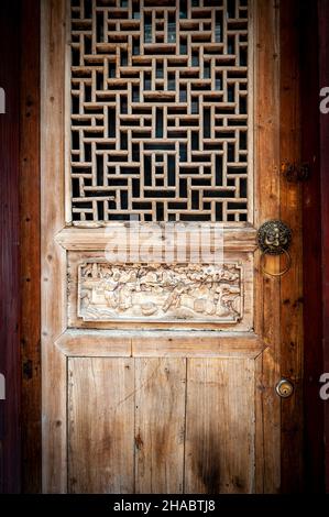 Close-up detail of ancient classic wooden door panel decorated with typical Chinese architecture style pattern and woodcarving Stock Photo