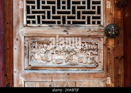 Close-up detail of ancient classic wooden door panel decorated with typical Chinese architecture style pattern and woodcarving Stock Photo