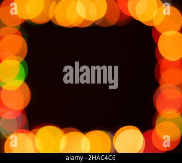 Blurred christmas lights frame on dark background Stock Photo