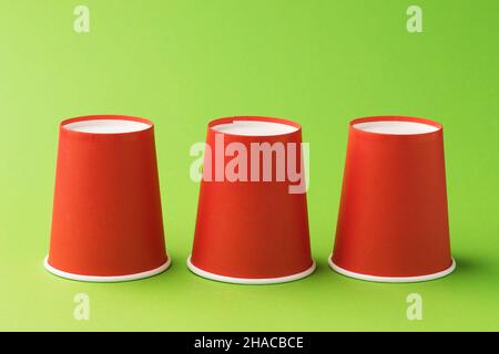 Inverted red paper cups on a green background Stock Photo