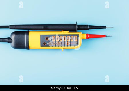 Two-pole voltage indicator close-up on a blue background. Testing and verification of electrical networks Stock Photo