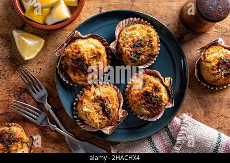 Delicious stuffed scallops on the half shell with celery, breadcrumbs and paprika. Stock Photo