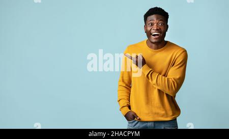 Cheerful african american millennial man pointing at copy space Stock Photo