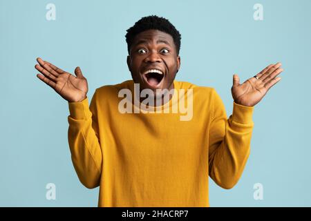 Surprised african american guy looking at camera, gesturing Stock Photo