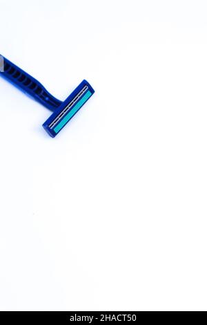 Flat Lay Shot of A Blue Razor in The Corner of Minimalist White Background, Portrait Mode Stock Photo
