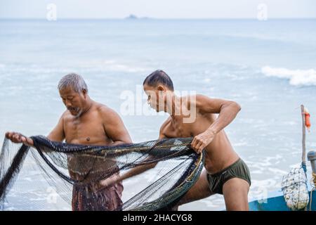 Phuket Thailand December 2021, the local fisherman on the beach of Naithonbury empty their fishing nets, Thai fisherman on the beach.  Stock Photo