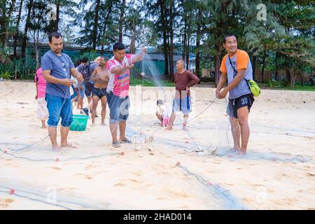 Phuket Thailand December 2021, the local fisherman on the beach of Naithonbury empty their fishing nets, Thai fisherman on the beach.  Stock Photo