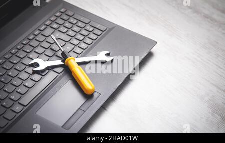 Wrench and screwdriver on the computer keyboard. IT Service. Support Stock Photo