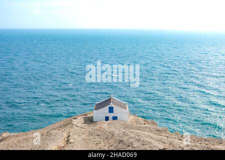 Simple house on the edge of a cliff overlooking the sea Stock Photo