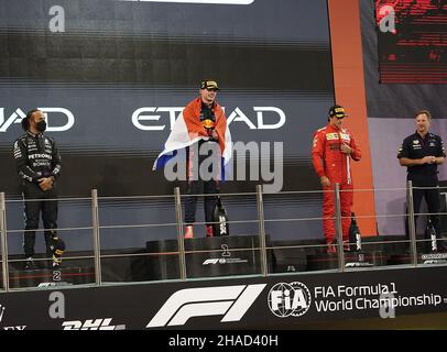 Abu Dhabi, United Arab Emirates. 12th Dec, 2021. Motorsport: Formula 1 World Championship, Abu Dhabi Grand Prix, race. Max Verstappen (2nd from left) of the Netherlands from Team Red Bull stands on the podium alongside runner-up Lewis Hamilton (l) of Great Britain from Team Mercedes and Carlos Sainz (2nd from right) of Spain from Team Ferrari and Christian Horner, team principal of Red Bull Racing. Verstappen has won the Formula 1 drivers' title for the first time and dethroned record world champion Hamilton. Credit: Hasan Bratic/dpa/Alamy Live News Stock Photo