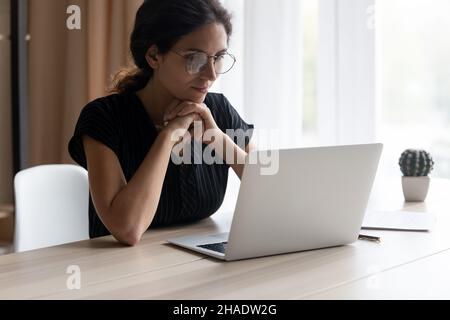 Young Latino woman work on computer online at home Stock Photo