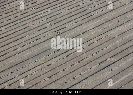 Background. Decking made of old bolted wooden battens. Remains of old cement between the slats Stock Photo
