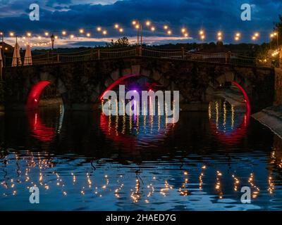 Night view of the illuminated medieval bridge of Jarandilla de la Vera in Cáceres, Extremadura. Stock Photo