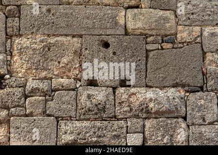background - antique stone wall made of huge blocks of various sizes and shapes Stock Photo