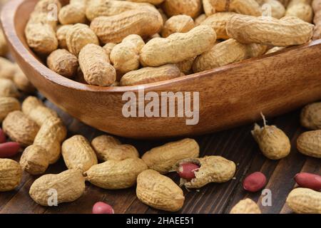 Raw organic peanuts in a wooden bowl. Stock Photo