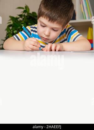Preschool child learns to write, writes copybook. Stock Photo