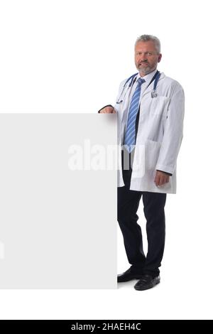 Mature male doctor holding blank placard banner isolated on white background Stock Photo