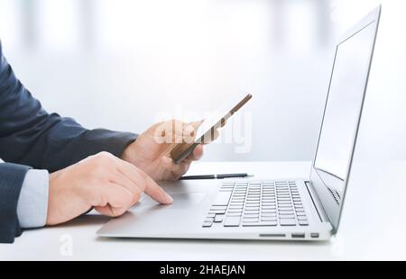 Man working with laptop and smart phone. Businessman, analyst in office Stock Photo