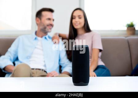 Couple using smart speaker, smart home system appliance, modern assistant Stock Photo