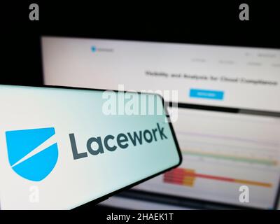 Mobile phone with logo of US cloud security company Lacework Inc. on screen in front of business website. Focus on center-left of phone display. Stock Photo