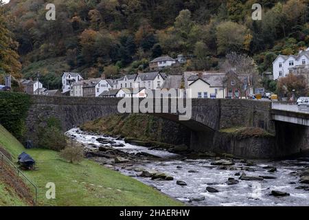 East Lyn River towards the centre of the village on 11th November 2021 in Lynmouth, United Kingdom. Lynmouth is a village on the northern edge of Exmoor. The village straddles the confluence of the West Lyn and East Lyn rivers, in a gorge 700 feet 210 m below Lynton. The South West Coast Path and Tarka Trail pass through Lynmouth which was made famous in when a devastating flood followed an intense storm leaving the village devastated. Overnight, over 100 buildings were destroyed or seriously damaged along with 28 of the 31 bridges. In total, 34 people died. Stock Photo