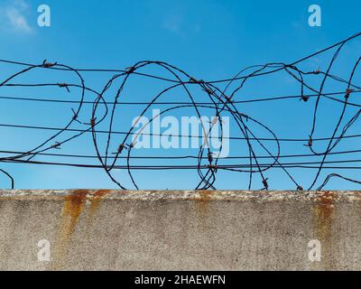 Concrete wall with barbed wire, the concept of prison, salvation, Refugee, lonely, copy space Stock Photo