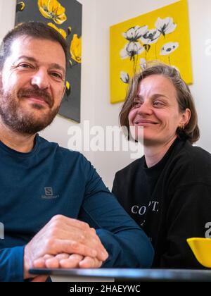 TOLEDO, SPAIN - Oct 29, 2021: A vertical shot of a beautiful happy Hispanic couple sitting at a table in the kitchen Stock Photo