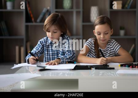 Happy adorable two children drawing pictures in album. Stock Photo