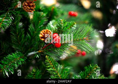 Christmas tree with decorations and pine cones, blurred background with bokeh. Celebrating New Year and Christmas. Stock Photo
