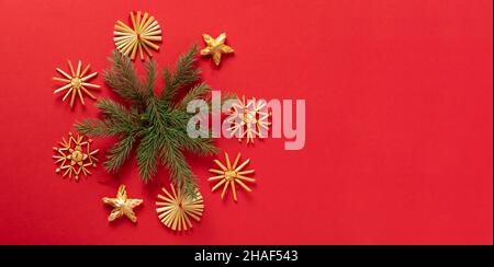 Fluffy branches of fir-tree Christmas toys made from natural materials of straw, red background. concept Christmas New Year. Stock Photo