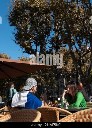 A young couple sitting outside in a french street cafe Stock Photo