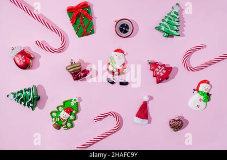 Various symbolic Christmas or New Year ornaments or decoration in red, green and white on pastel pink background. Pattern or wallpaper for festive car Stock Photo