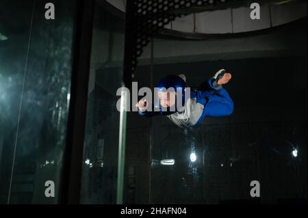 A man teaches a boy to fly in a wind tunnel. Stock Photo