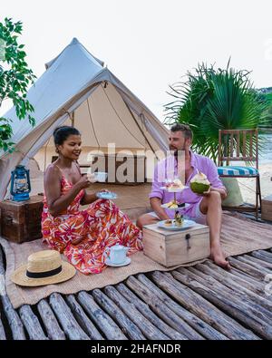 Couple picnic in front of tent on the beach in Thailand. man and woman mid age beach glamping in Phuket Stock Photo