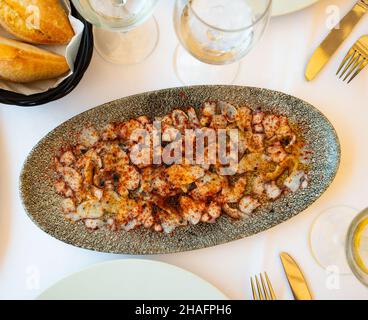 Delicious octopus carpaccio seasoned with aromatic oil and smoked paprika served on plate. Seafood appetizer Stock Photo