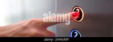 Woman finger presses a button in elevator closeup Stock Photo