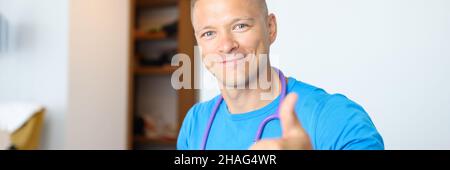 Smiling male doctor making thumbs up gesture Stock Photo