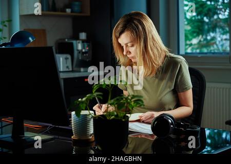 Thirty years old tired man working late remotely at home office, using computer, remote work burnout Stock Photo