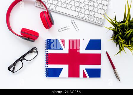 Student table desk with British flag and headphones. Online language courses Stock Photo