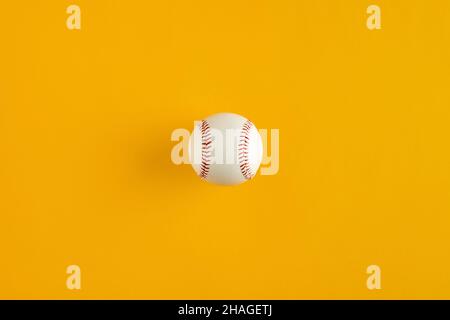 Baseball ball on yellow background with copy space. Top view. Stock Photo