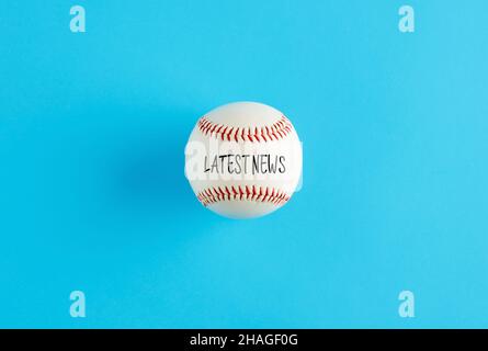 Baseball ball on blue background with the word latest news. Baseball league news announcement concept. Stock Photo