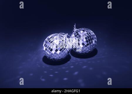 two mirror balls illuminated by bright light on dark violet background Stock Photo