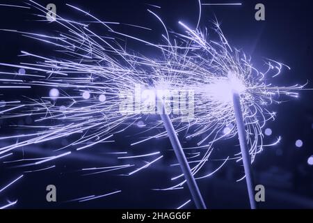 Bright glittering sparkler on blurred bokeh background Stock Photo