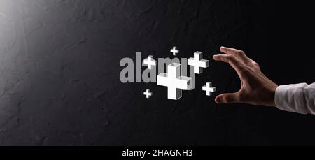 Hand hold 3D plus icon, man hold in hand offer positive thing such as profit, benefits, development, CSR represented by plus sign.The hand shows the p Stock Photo